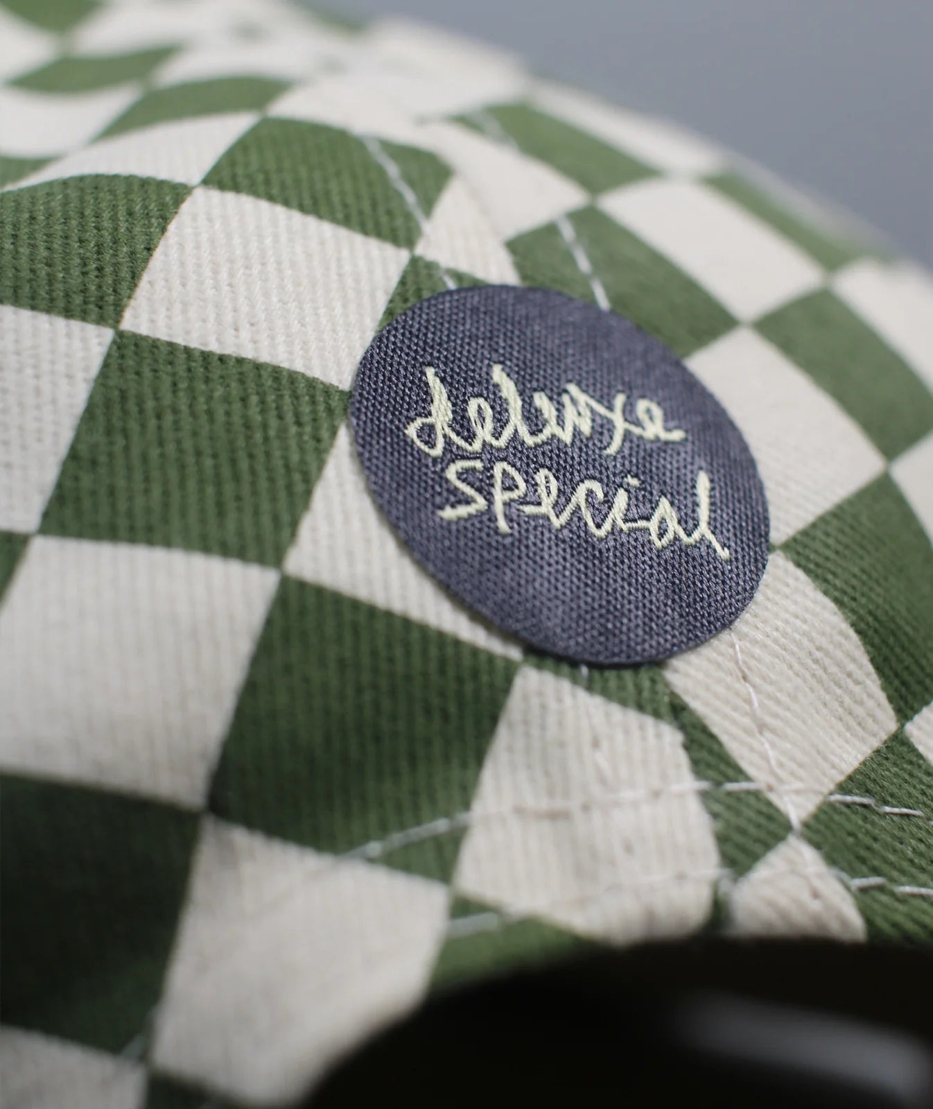 Green and white checkered hat with Deluxe Special patch