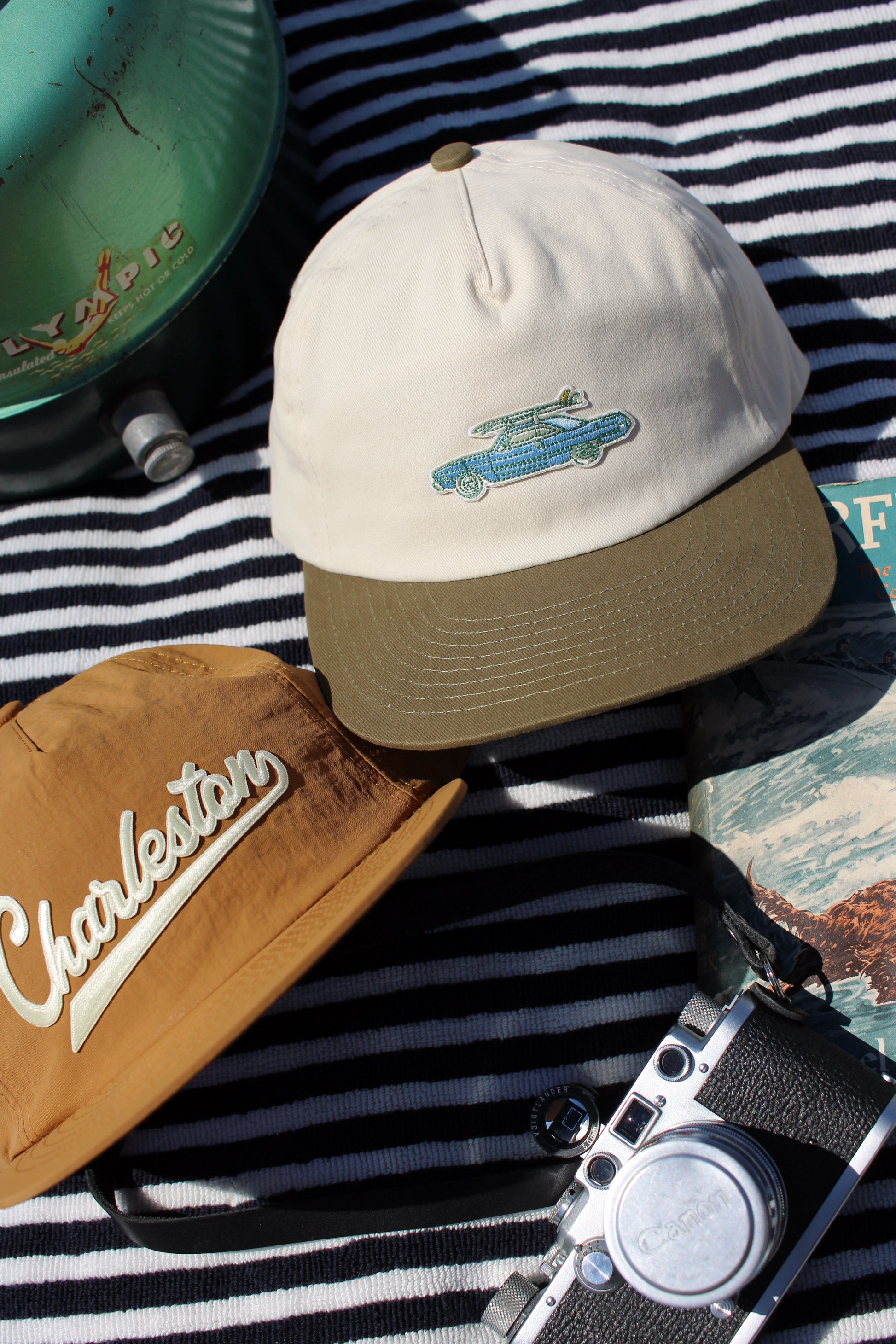 Hat with a vintage car surfboard design on a chair with a camera and colorful object