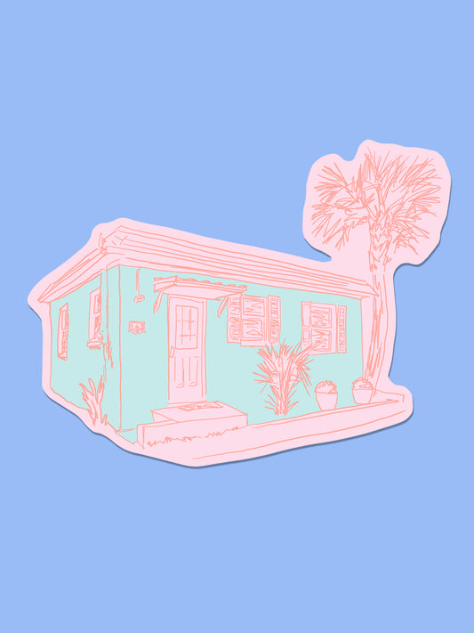 A die-cut sticker featuring a minimalist pink line art illustration of a house with a palm tree, shown on a solid light blue background.