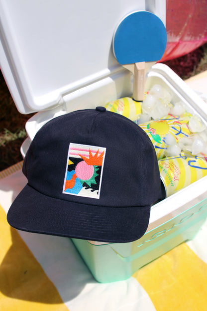 Navy cap with colorful design on a cooler with drinks