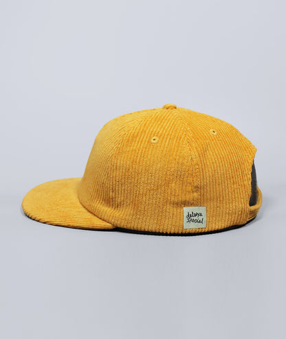 Yellow corduroy cap with a brand label on a gray background